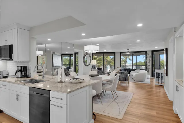 a kitchen with a sink dishwasher a refrigerator and a stove with wooden floor