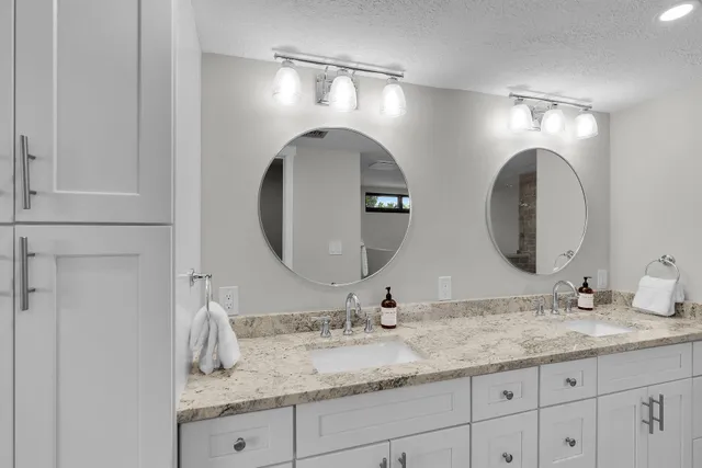 a bathroom with double vanity sinks and a mirror