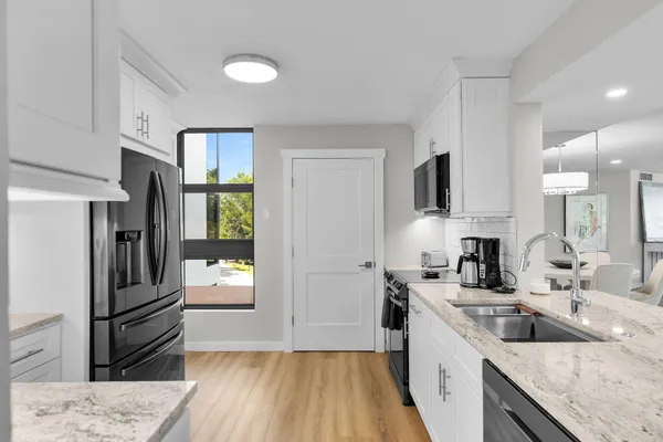 a kitchen with a refrigerator and a sink