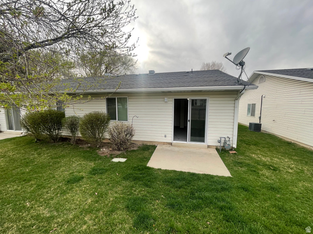 101 1501 Monroe, Unit 101 Ogden, UT 84404 - Photo 22 of 24 Rear view of house featuring a patio area, a lawn, and a shingled roof