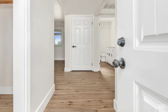 a view of a hallway with wooden floor and staircase
