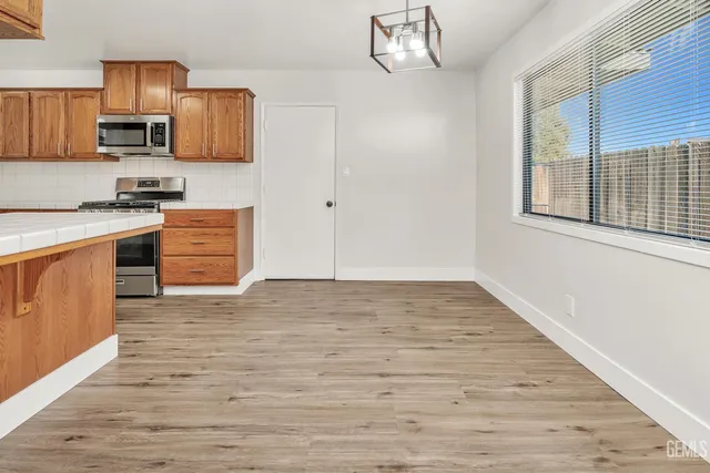 a kitchen with stainless steel appliances granite countertop a stove a sink and a refrigerator
