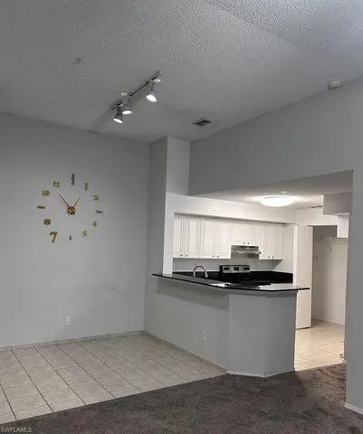 a kitchen with kitchen island stainless steel appliances a sink a stove and a refrigerator