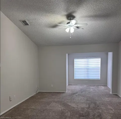 a view of an empty room with a chandelier fan