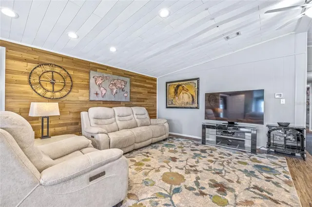 a view of a dining room with furniture a chandelier and wooden floor