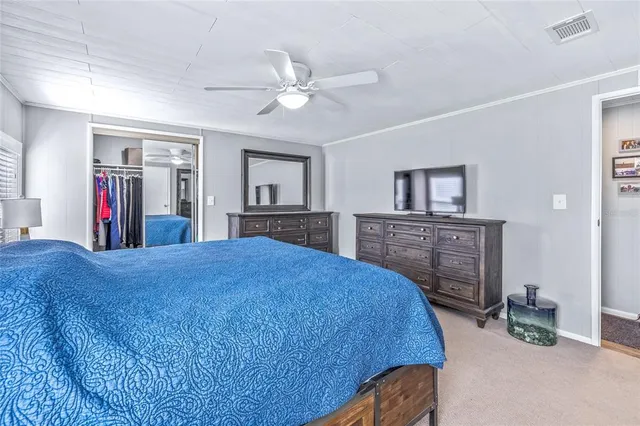 a bedroom with a bed a large window and walk in closet