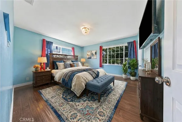 a bedroom with a large bed and a flat tv screen