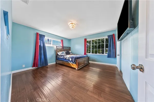 a bedroom with a bed and a flat screen tv