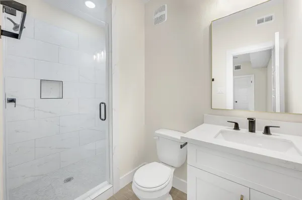 a bathroom with a sink a toilet and shower