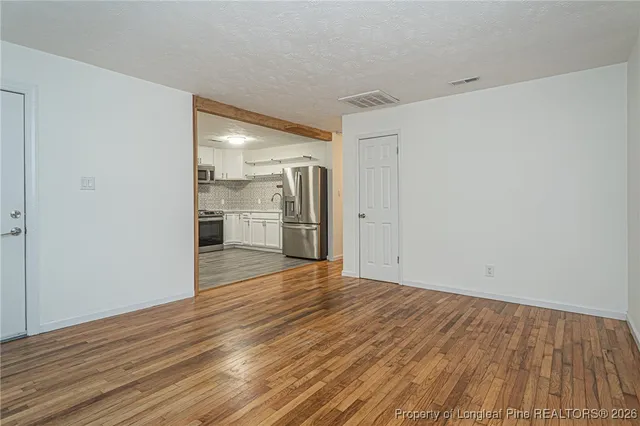 a view of empty room with wooden floor