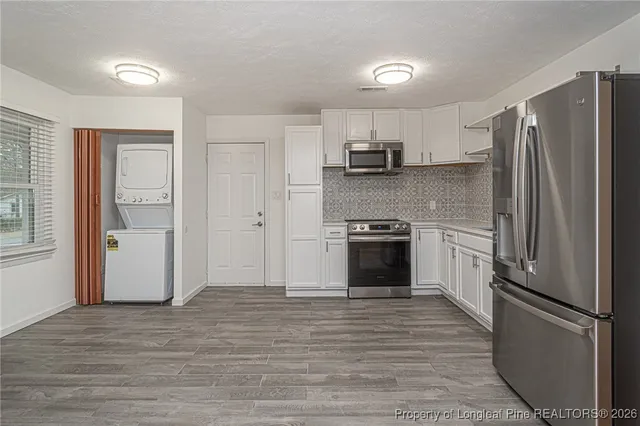 a kitchen with stainless steel appliances a refrigerator sink and cabinets