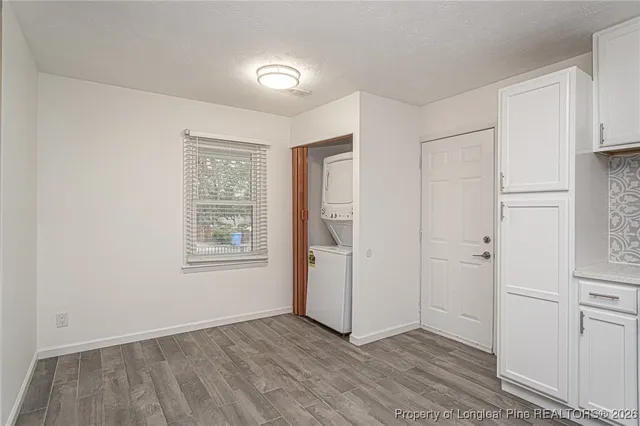a view of an empty room with closet and a window