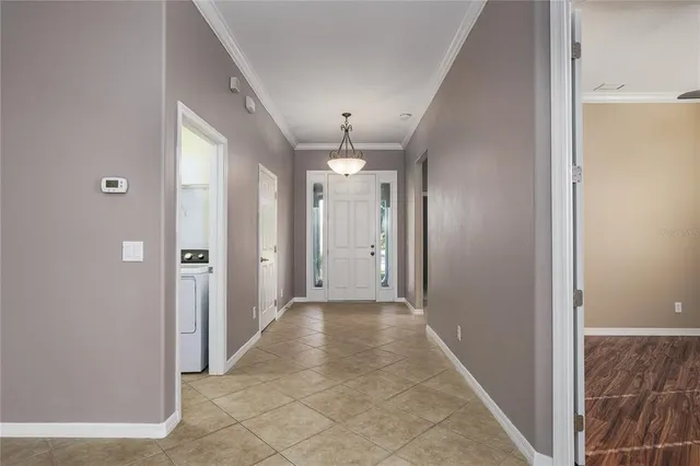 a view of a hallway with chandelier and entryway