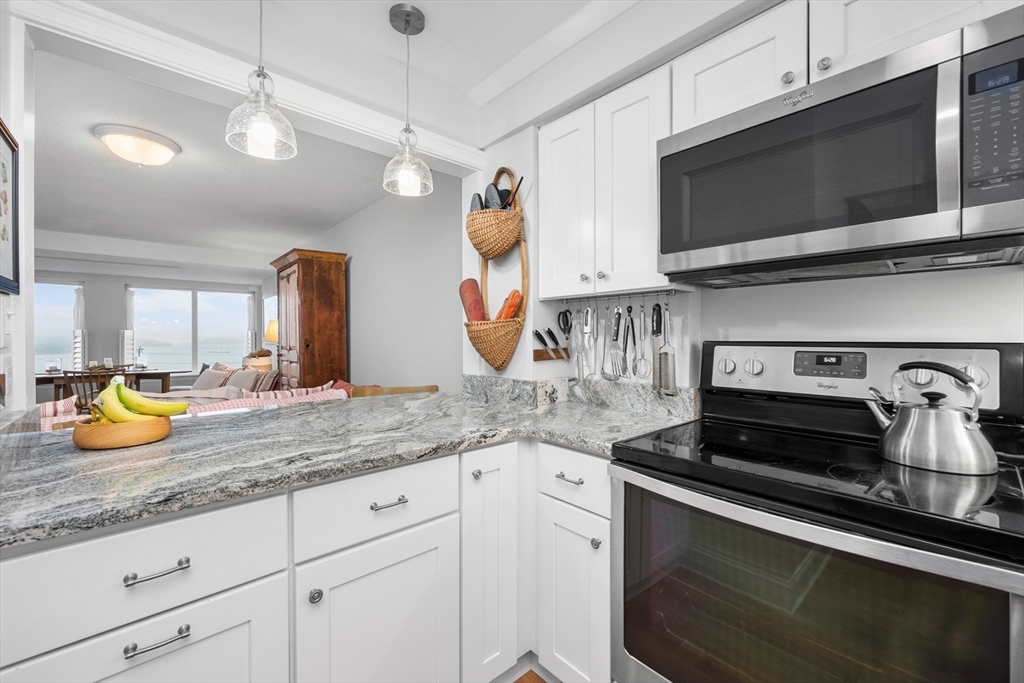 9 Park Hull Ma, Unit 505 Hull, MA 02045 - Photo 12 of 25 a kitchen with stainless steel appliances granite countertop a sink a stove and cabinets