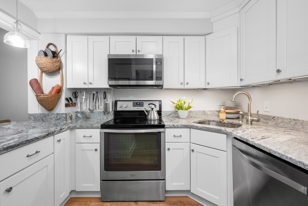 9 Park Hull Ma, Unit 505 Hull, MA 02045 - Photo 14 of 25 a kitchen with granite countertop white cabinets and white appliances