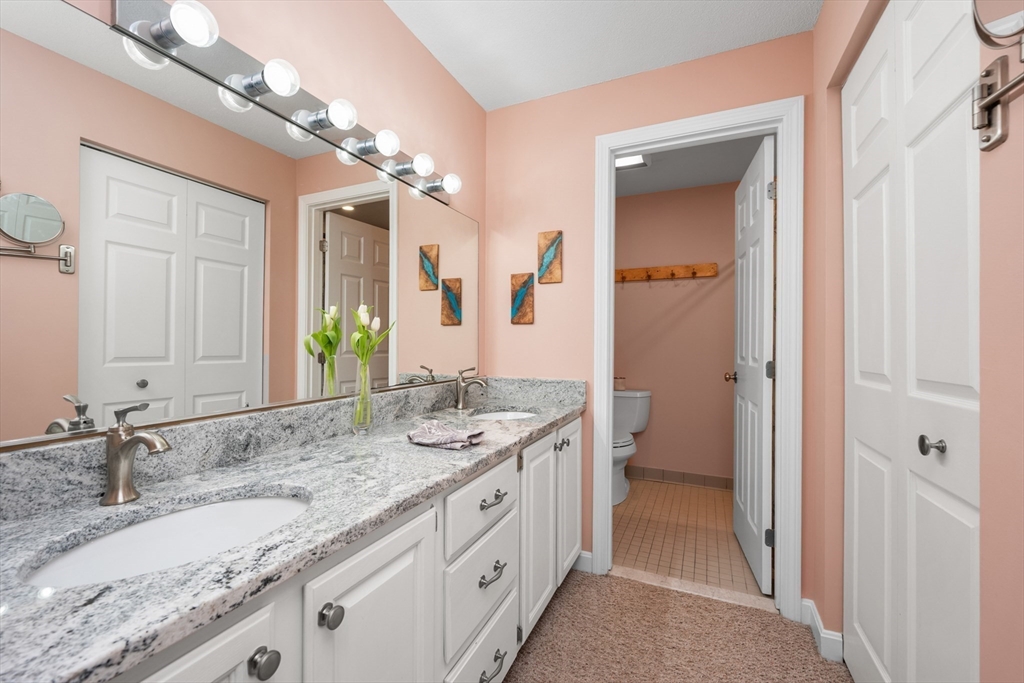 9 Park Hull Ma, Unit 505 Hull, MA 02045 - Photo 19 of 25 a spacious bathroom with a granite countertop double vanity sink a mirror and a shower