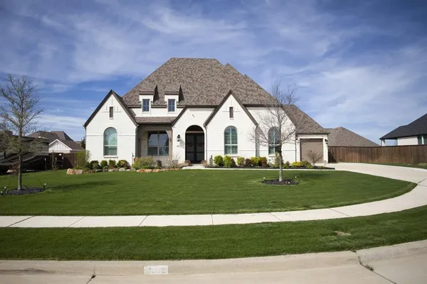 a view of a white house with a yard