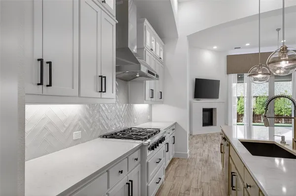 a kitchen with stainless steel appliances a stove a sink and cabinets