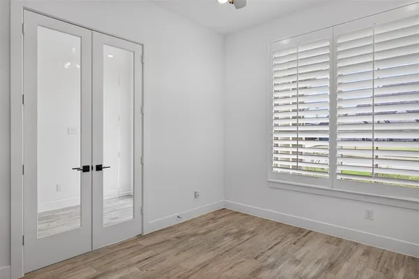 a hallway with wooden floor and cabinet
