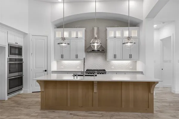 a kitchen with stainless steel appliances granite countertop a sink a stove and a refrigerator