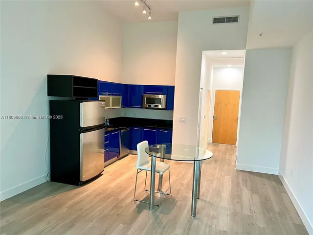 a kitchen with stainless steel appliances kitchen island granite countertop wooden floors
