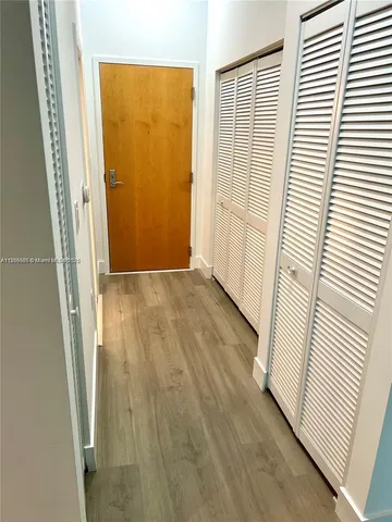 an entryway with wooden floor and a window