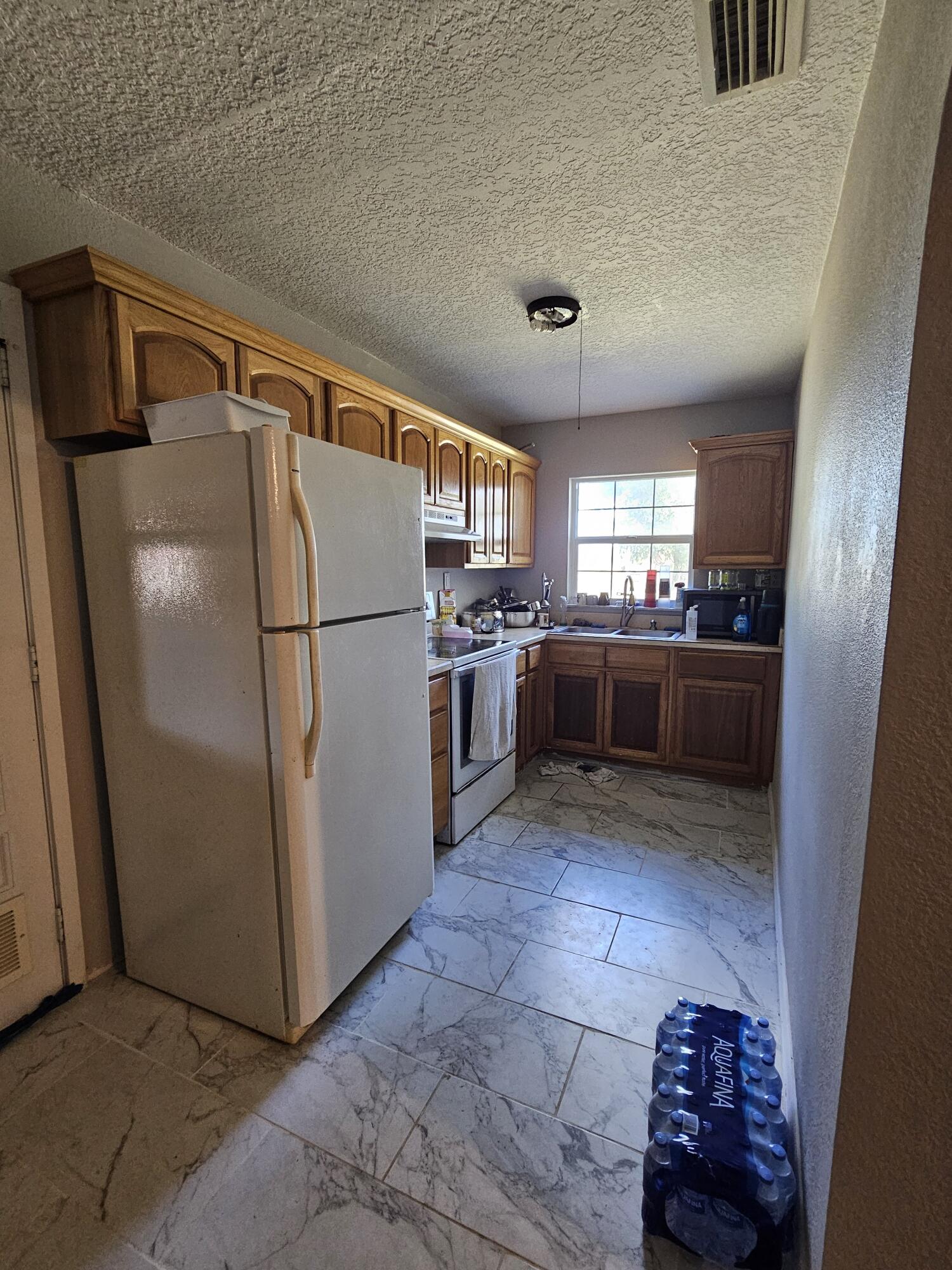4900 Northwest 160th Street Okeechobee, FL 34972 - Photo 11 of 23 a kitchen with stainless steel appliances granite countertop a refrigerator and a stove