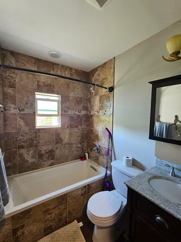 a bathroom with a granite countertop toilet sink and bathtub