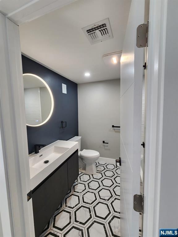 93 Hughes Street, Unit 4 Maplewood, NJ 07040 - Photo 13 of 20 a bathroom with a sink a toilet and a mirror