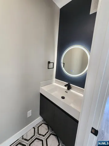 a bathroom with a toilet sink vanity and mirror
