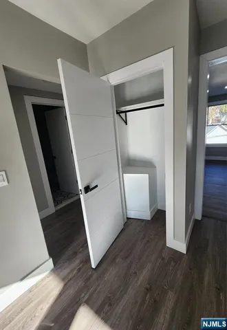 a view of a hallway with wooden floor and stairs