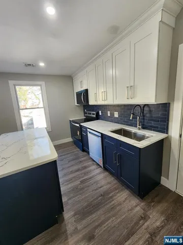 a kitchen with a sink a stove and cabinets