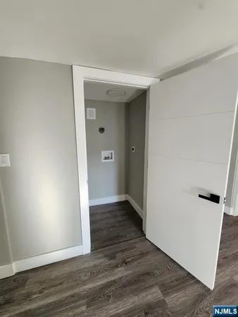 an empty room with wooden floor and entrance