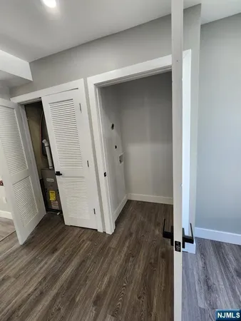 an empty room with wooden floor and a ceiling fan