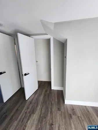 an empty room with wooden floor and white doors