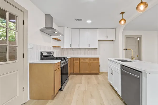 a kitchen with stainless steel appliances granite countertop a stove a sink and a refrigerator