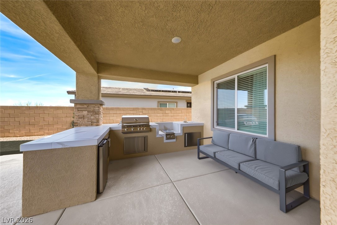 290 Rusty Ridge Lane Henderson, NV 89015 - Photo 45 of 61 Backyard w/pool & spa, desert rock w/synethic grass & pavers, built in outdoor kitchen w/fridge, cooktop & sink & No Rear Neighbors.
