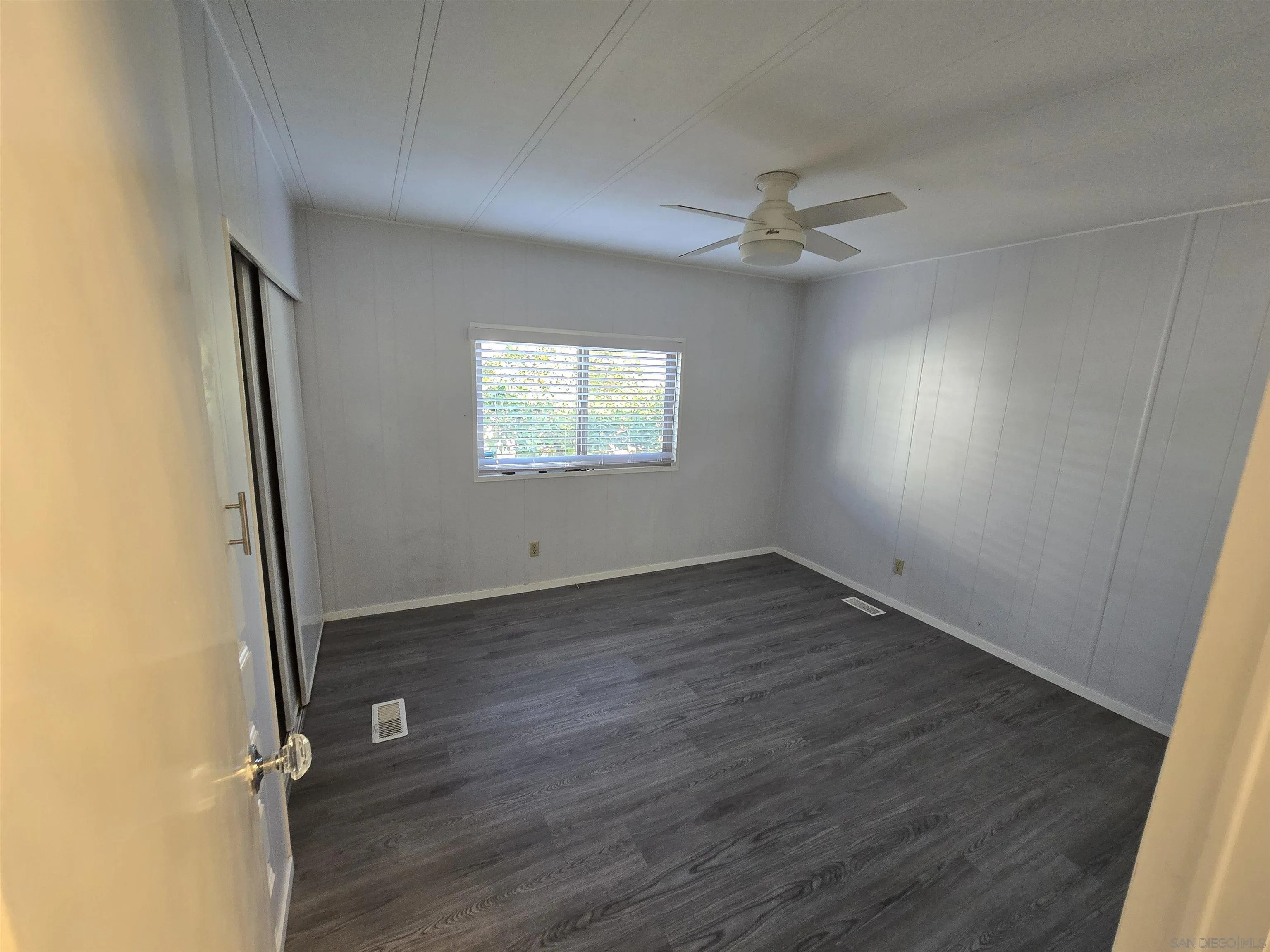 1815 Sweetwater Road, Unit SPC 120 Spring Valley, CA 91977 - Photo 14 of 49 an empty room with wooden floor ceiling fan and windows