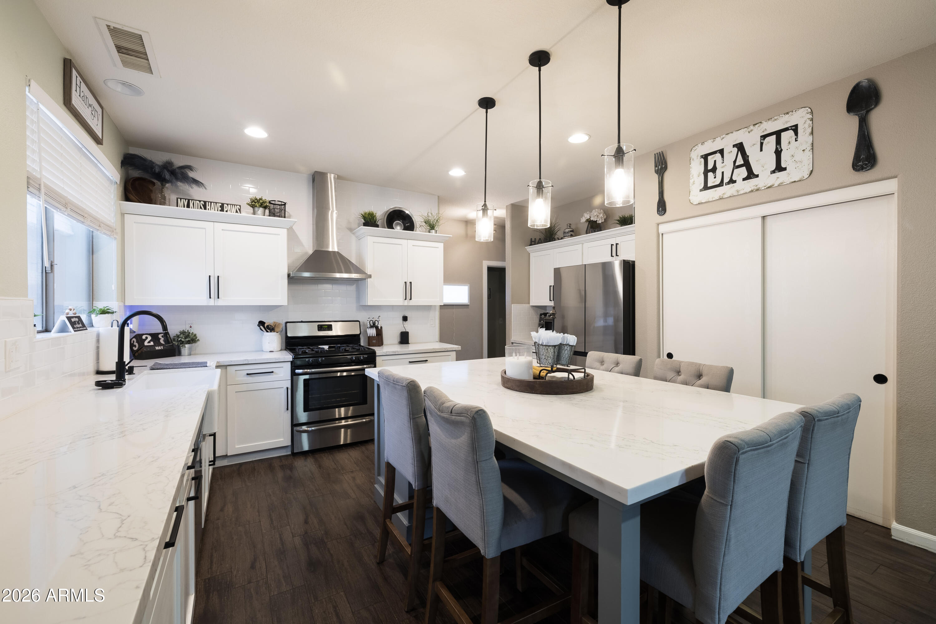 6407 West Saddlehorn Road Phoenix, AZ 85083 - Photo 23 of 41 a kitchen with a stove a refrigerator a sink a dining table and chairs with wooden floor