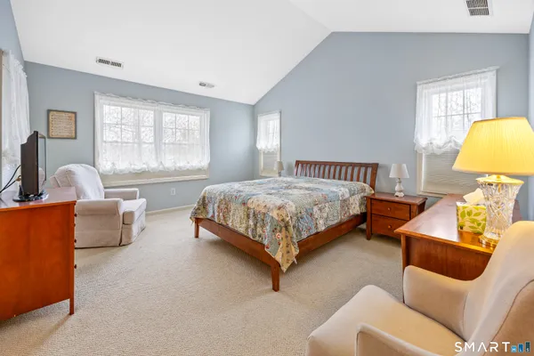 a bedroom with a bed and a couch next to a window