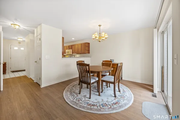 a dining room with furniture a chandelier and wooden floor