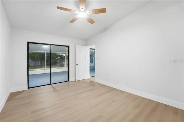 an empty room with fan and entrance