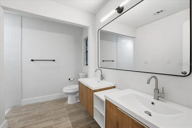 a bathroom with a toilet sink and mirror