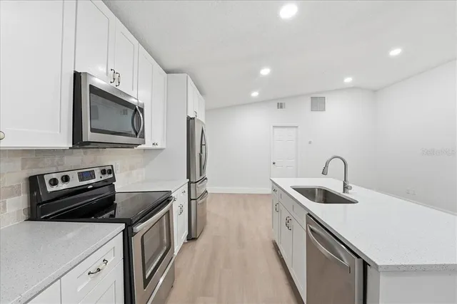 a kitchen that has a sink and a stove top oven