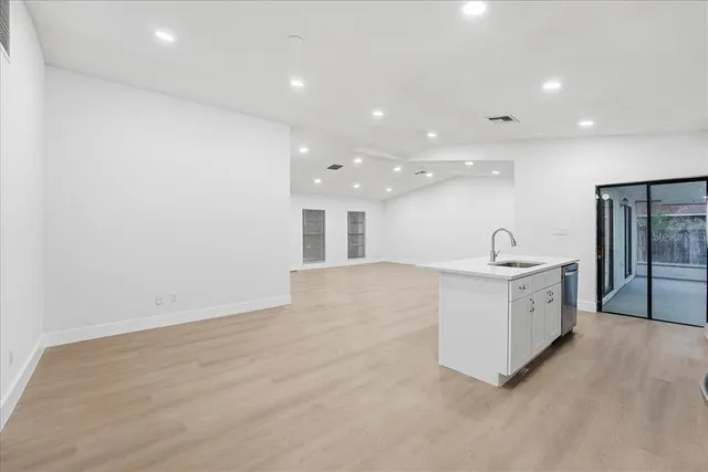 a large white kitchen with a sink a refrigerator and a stove