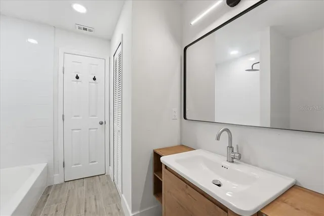 a bathroom with a sink mirror and shower