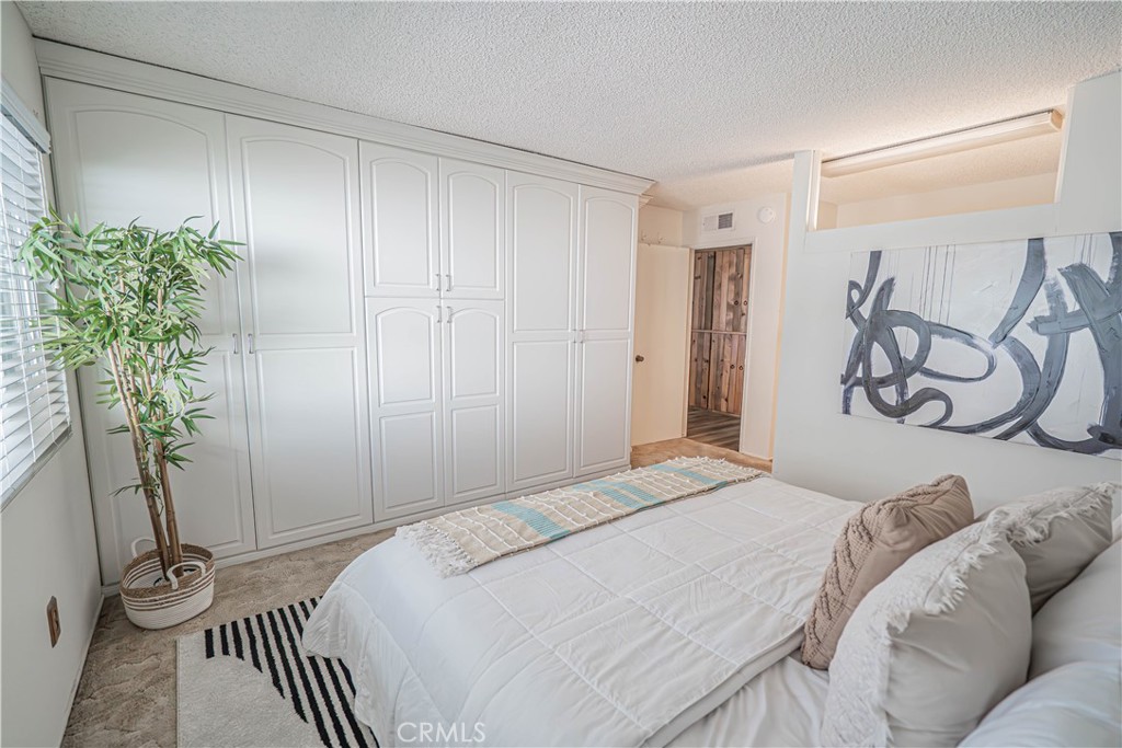 26478 Fairway Circle Newhall, CA 91321 - Photo 17 of 60 a bedroom with a bed and a potted plant