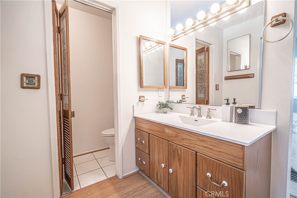 26478 Fairway Circle Newhall, CA 91321 - Photo 20 of 60 a bathroom with a sink a toilet and mirror