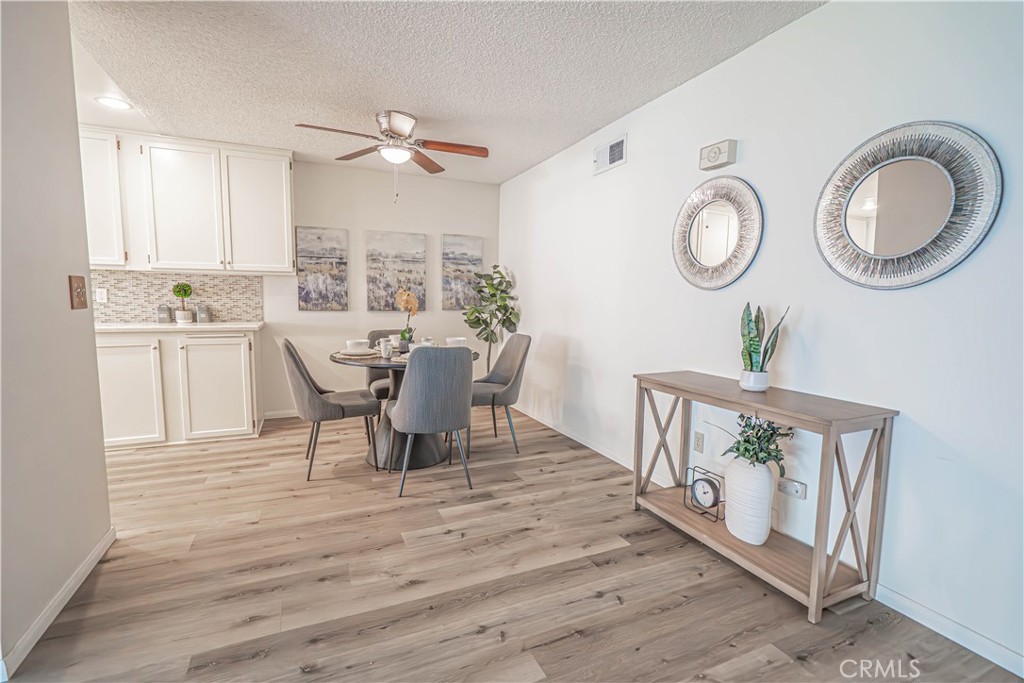 26478 Fairway Circle Newhall, CA 91321 - Photo 6 of 60 a view of a dining room with furniture a potted plant and wooden floor