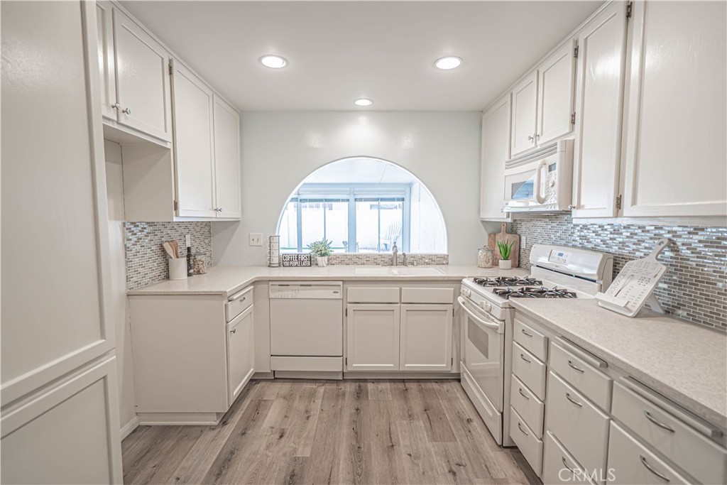 26478 Fairway Circle Newhall, CA 91321 - Photo 9 of 60 a kitchen with a sink cabinets wooden floor and stainless steel appliances